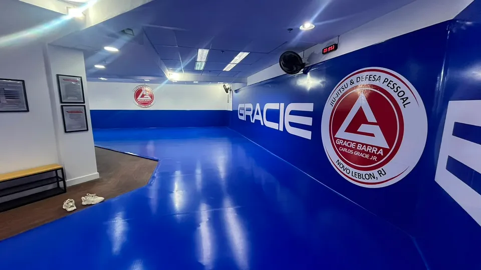 Tatame com a marca Gracie Barra na parede