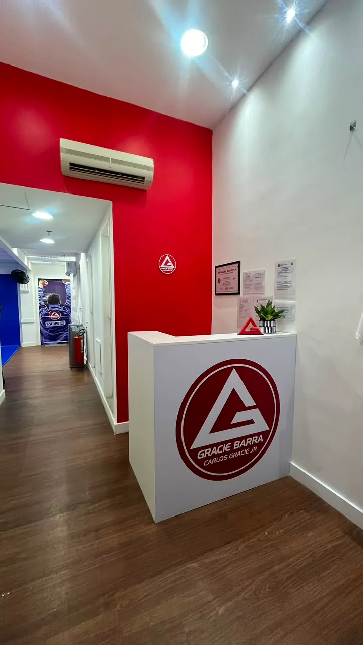 Recepção da escola, com o balcão da Gracie Barra e o corredor de acesso ao tatame